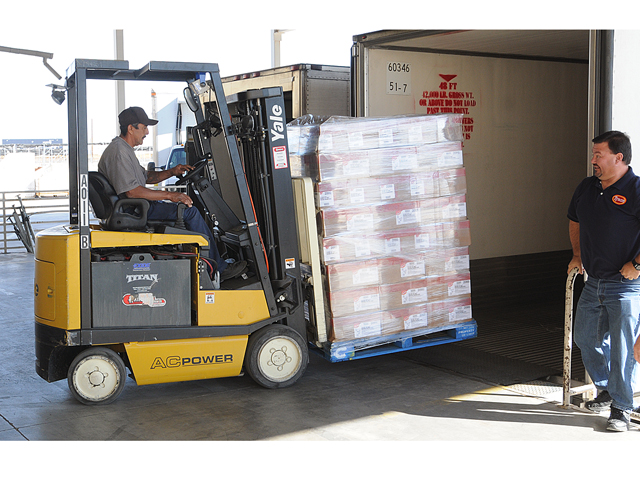 We got chicken! -- As Tyson Foods, Inc., truckdriver Dustin Crawford (right) looks on, Yuma Community Food Bank forklift operator Miguel De La Cruz removes a pallette of chicken from the back of a semi truck trailer to be stored inside the Food Bank warehouse Thursday morning. Tyson Foods donated 30,000 pounds of chicken to the Food Bank as part of an effort to feed people in need and to promote pulic awareness of hunger in America. In September Tyson Foods conducted a Facebook poll in which people were asked to vote for the food bank they would support to get a truckload of food. Ten food banks were selected to be in the poll, from among the most food insecure communities in the U.S. The top three vote-getters, including Yuma Community Food Bank, are getting a truckload of food this month. The top three vote getters in the poll were Food Bank of the Albemarle, Elizabeth City, N.C. (9,467 votes); Yuma Community Food Bank (9, 435 votes); and Mississippi Food Network, Jackson, Miss. (3, 425 votes). Photo by Ra